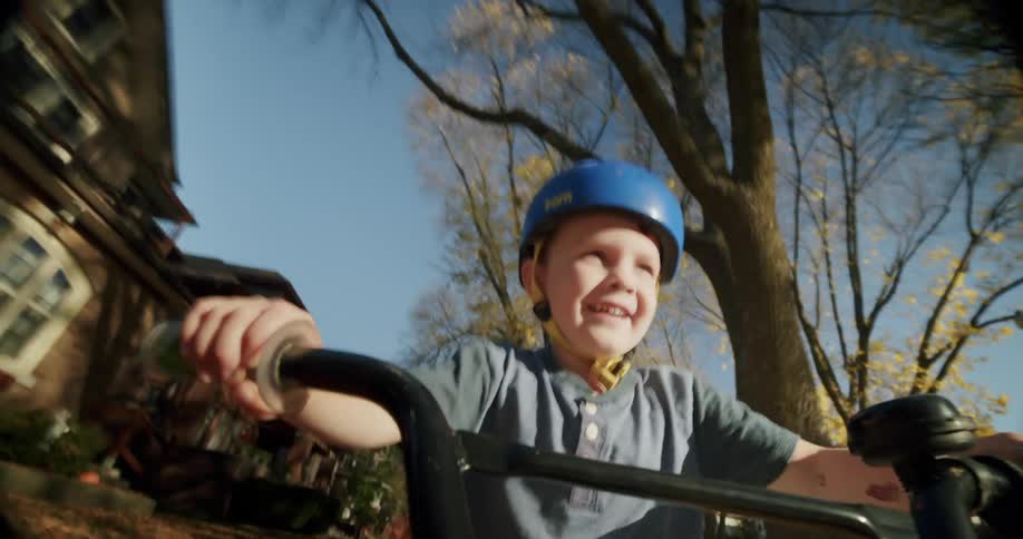 Point of view of happy child riding his bike through the neighborhood