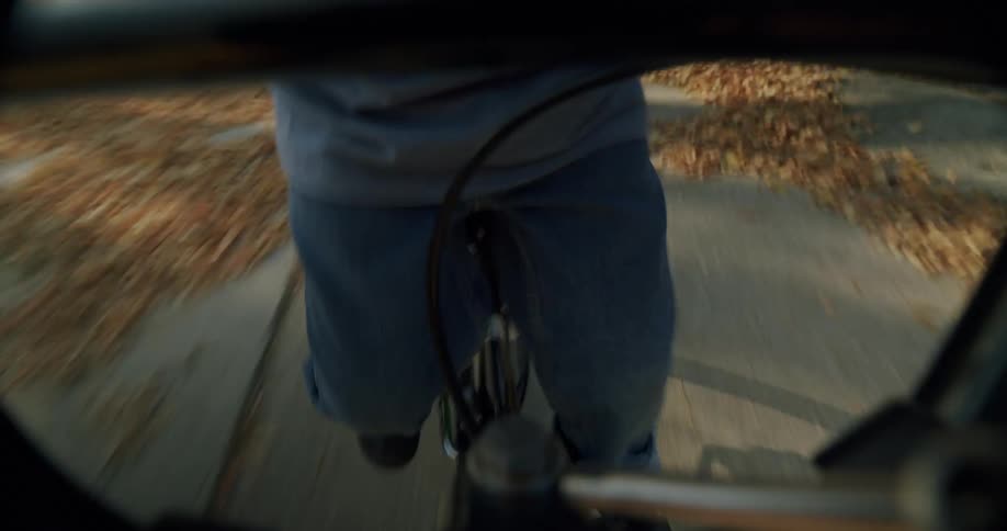 A child is riding a bicycle on the sidewalk