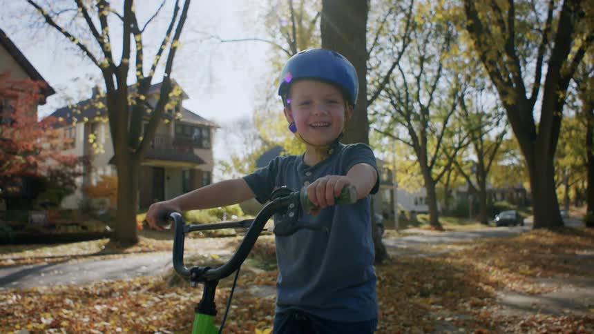 Happy little boy with helmet on a bike
