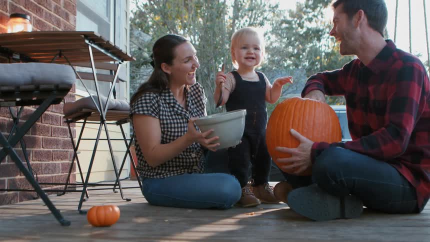 A family carve a pumpkin together