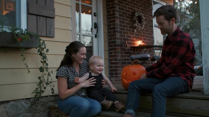 A family talk and smile outside their home