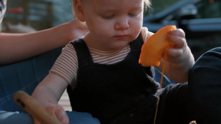 Little boy next to his mother taking a piece of pumpkin