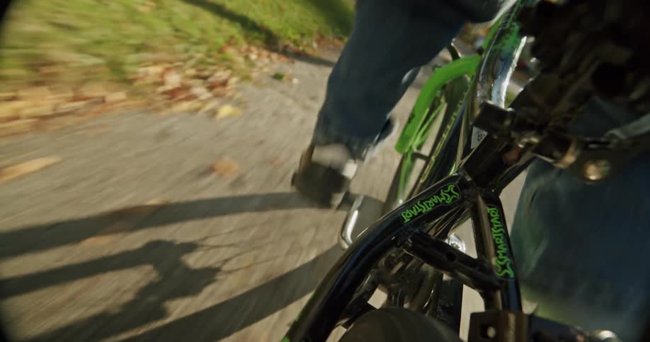 Closeup of a boy riding a bicycle down the sidewalk