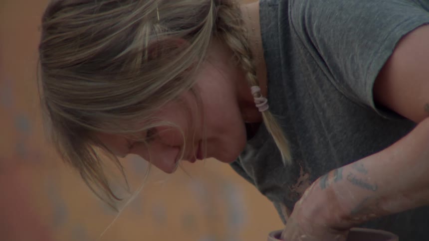 A woman is sculpting a vase