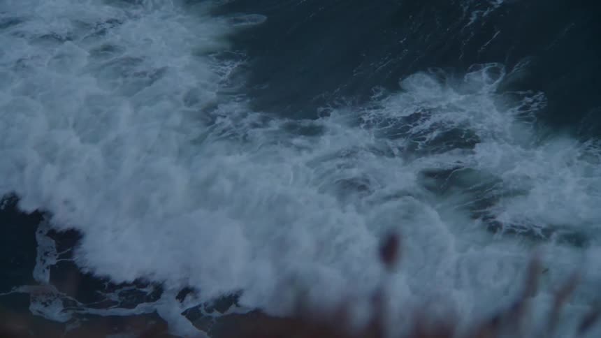 A closeup of foamy waves crashing against the shore