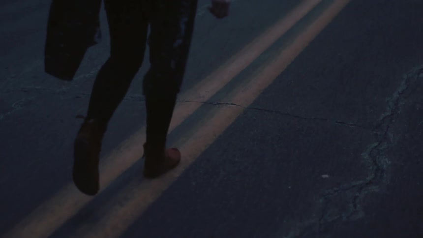 Person walking on the double yellow line of a road