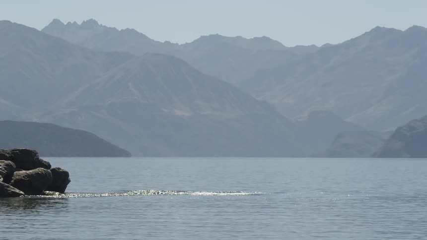 A man jumps into water from a rock