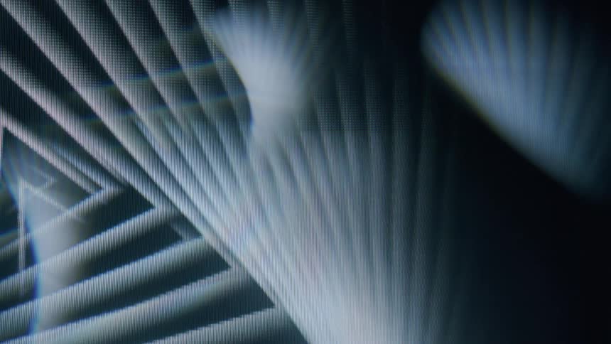The overlapping fan shaped light beams create a layered geometric pattern in shades of gray and black