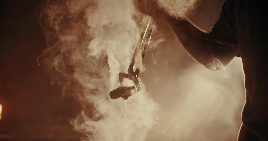 Silhouette of a person forging a hammer