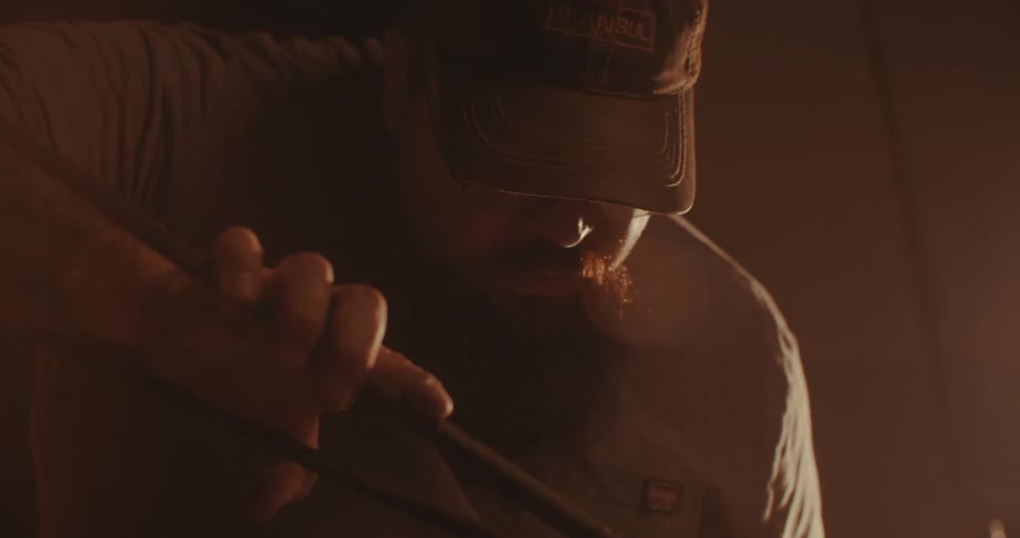 Man in cap forging hot metal