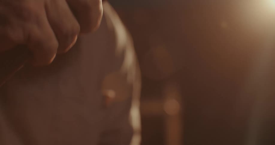 Man hammering a thin wooden rod into a metal support