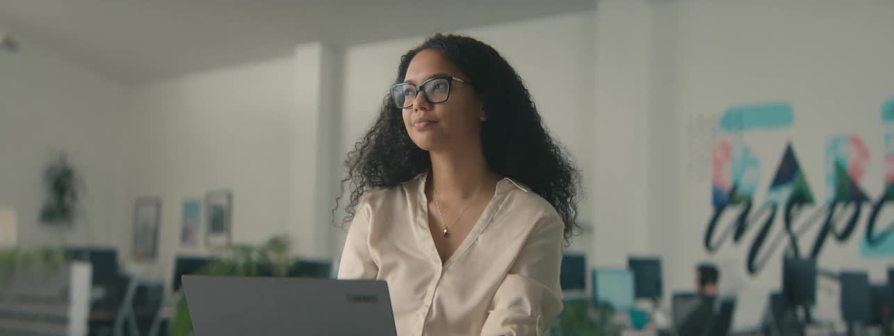 A woman is looking at his laptop in the office