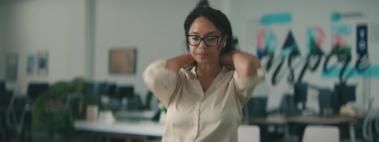 Woman in an office environment drinking a cup of tea and then interacting with a laptop