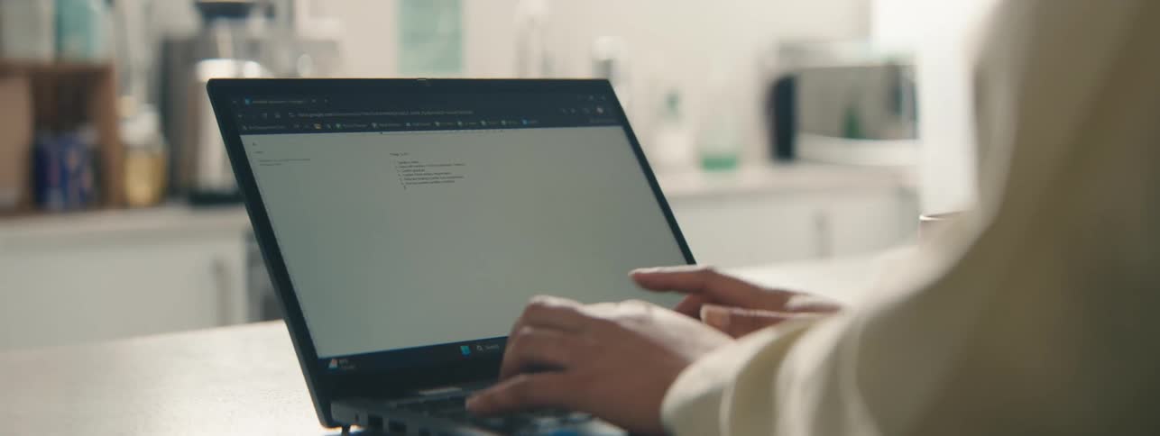 Hands of a woman typing quickly on a laptop