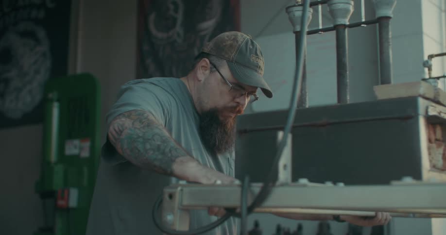 Man in a cap moving a table with an industrial machine