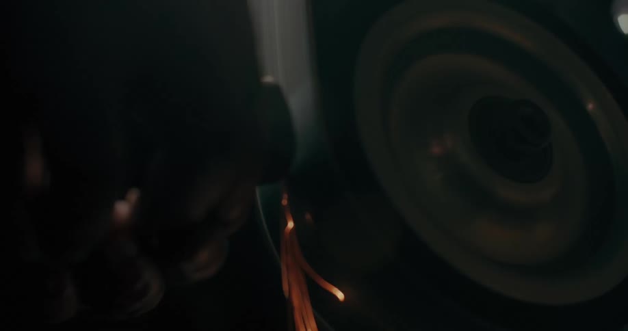 A blacksmith is using a grinder