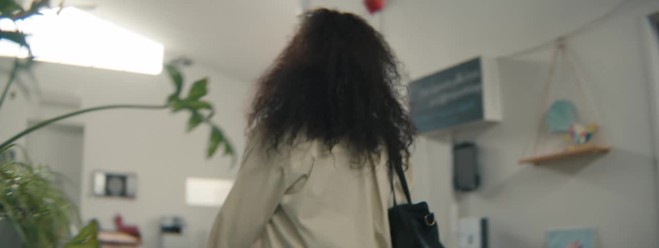 Cheerful woman walking down a hallway in an office environment