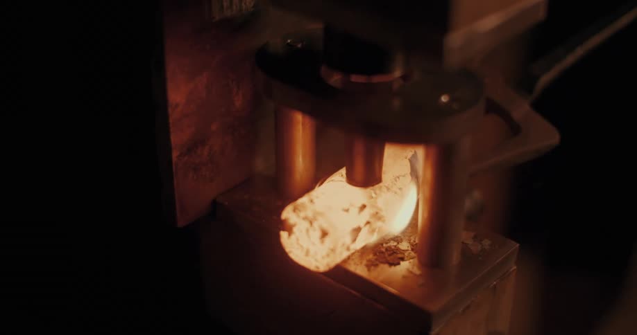 Machine making a hole in a hot iron