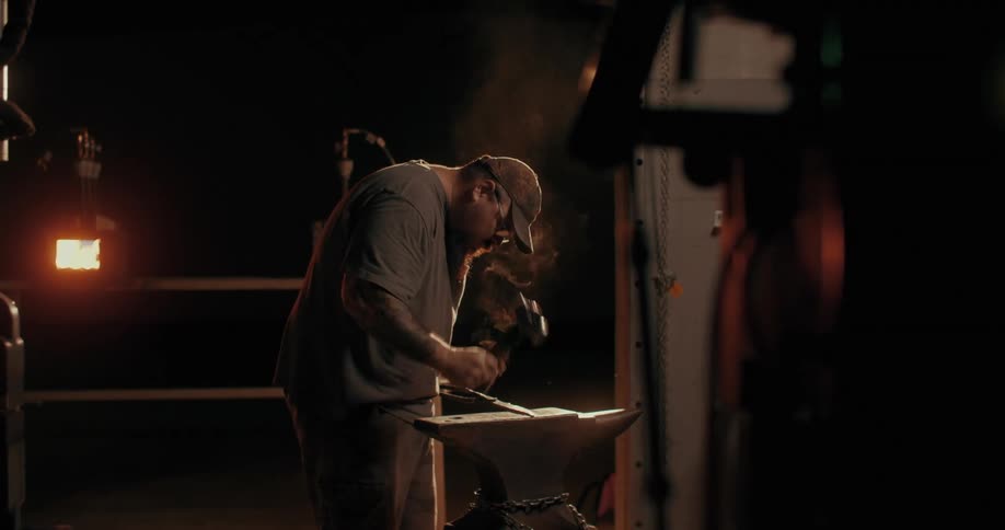 A man is hammering on an anvil