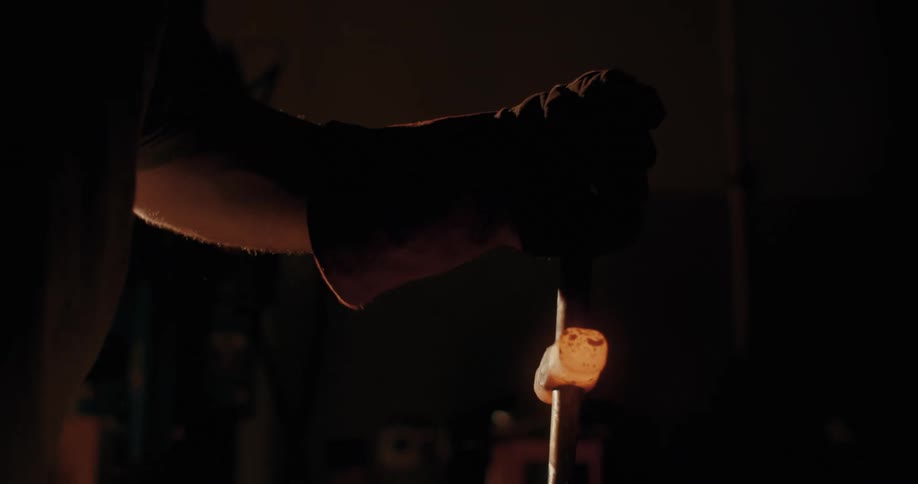 A blacksmith shaping a hammer head over an anvil