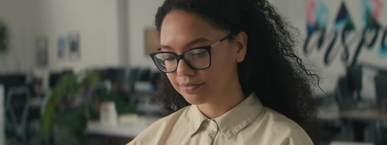 Woman with glasses concentrating while standing in an office room