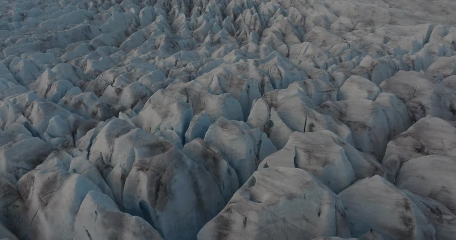 A field filled with an unusual snow formation near a mountain