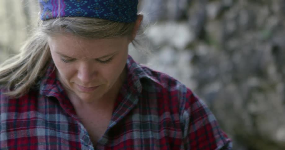 Woman wearing a flannel shirt and headband looking down