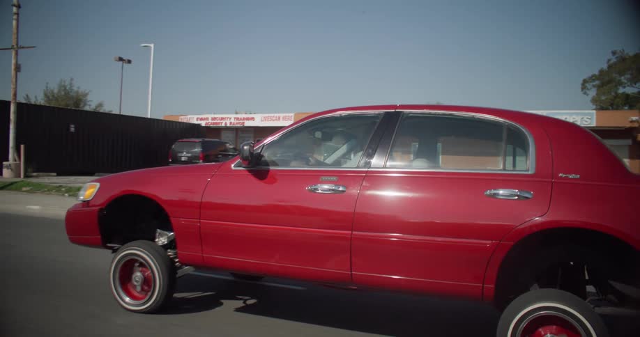 A red car pops a wheelie