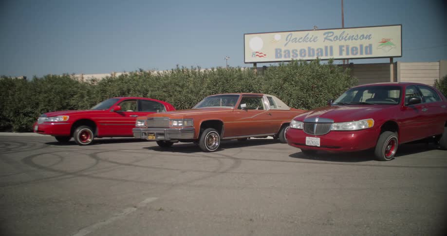 A few old cars are parked