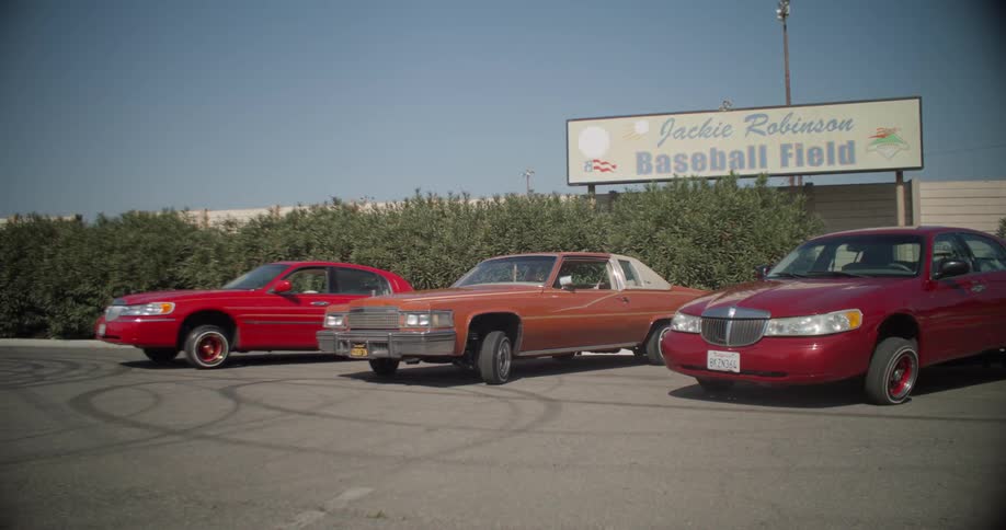 A few old cars are parked