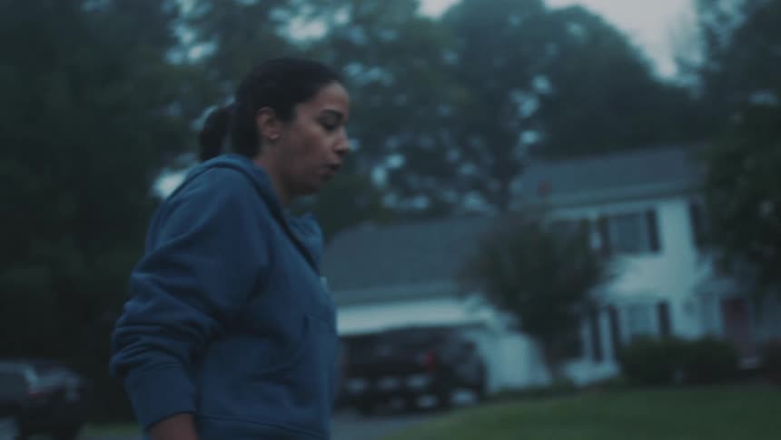 Woman in jacket running on a cloudy day