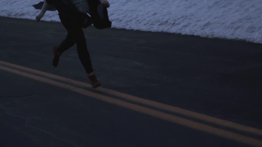 A woman runs on a road in the winter