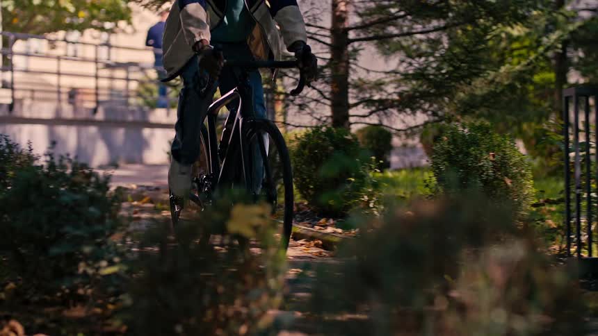 Close up of a person riding a bicycle through a park