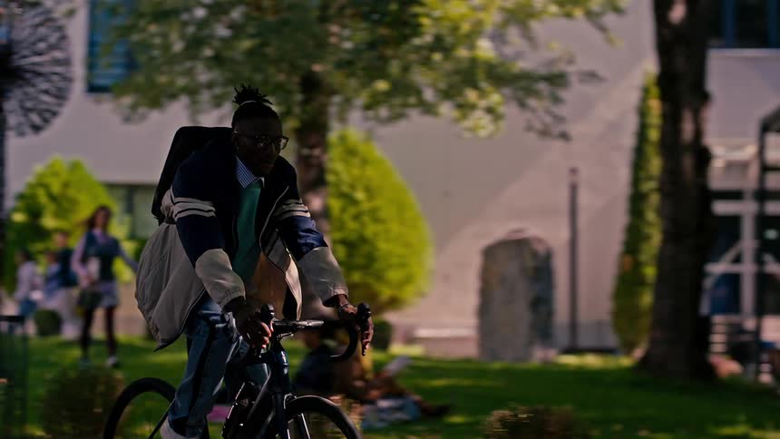 Woman walking reading a book and a man riding a bicycle outside