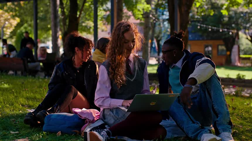 A group of friends relaxing on a park in the college campus