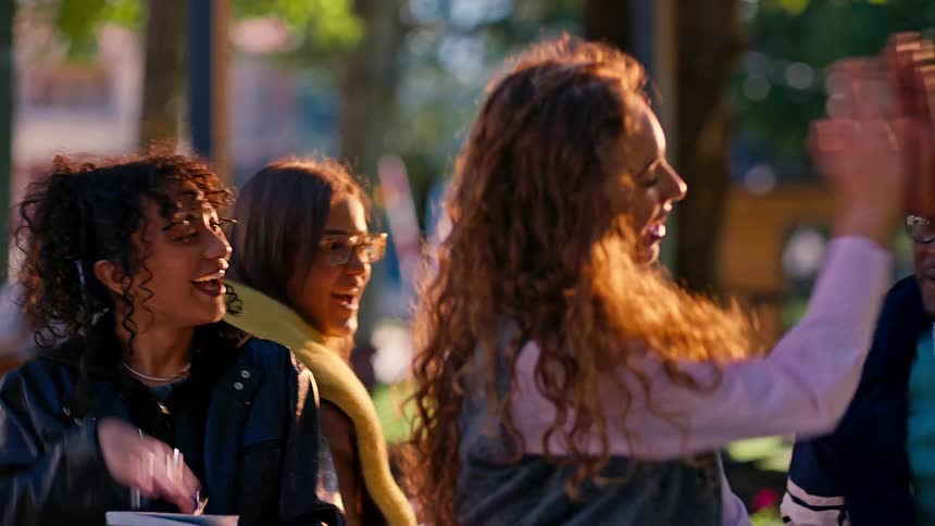 College students sitting in a public office greeting each other and talking