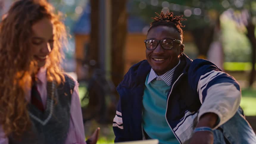 College students sitting on the grass talking to each other
