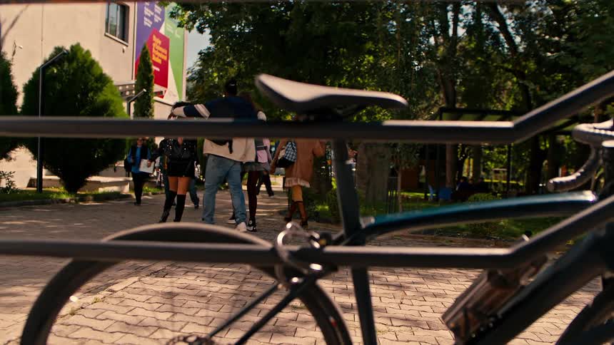 Man locking his bike to a metal fence on a university campus
