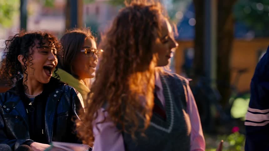 College students sitting on a campus talking and greeting each other