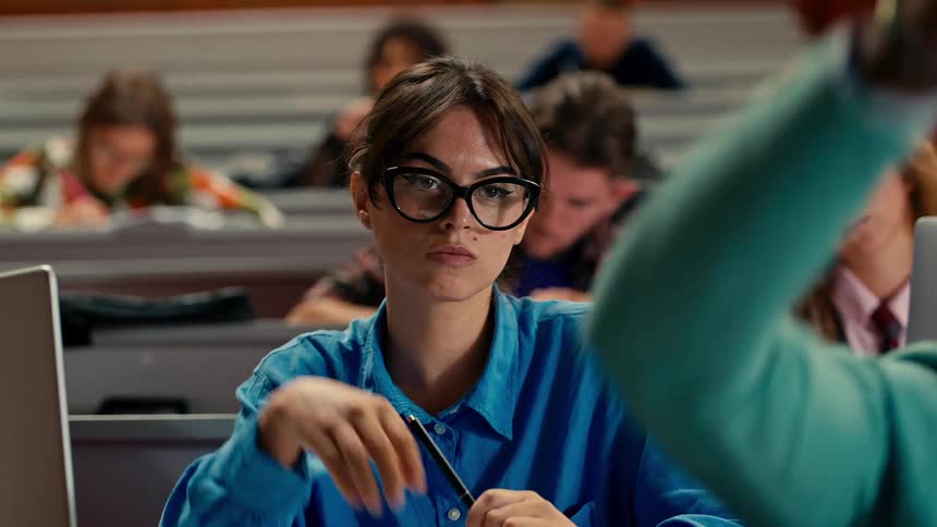 College students raising their hands in class