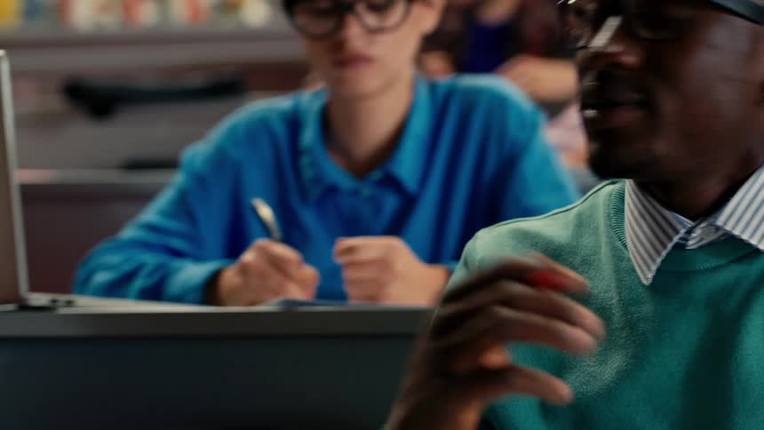 College students talk to each other in low voices during class