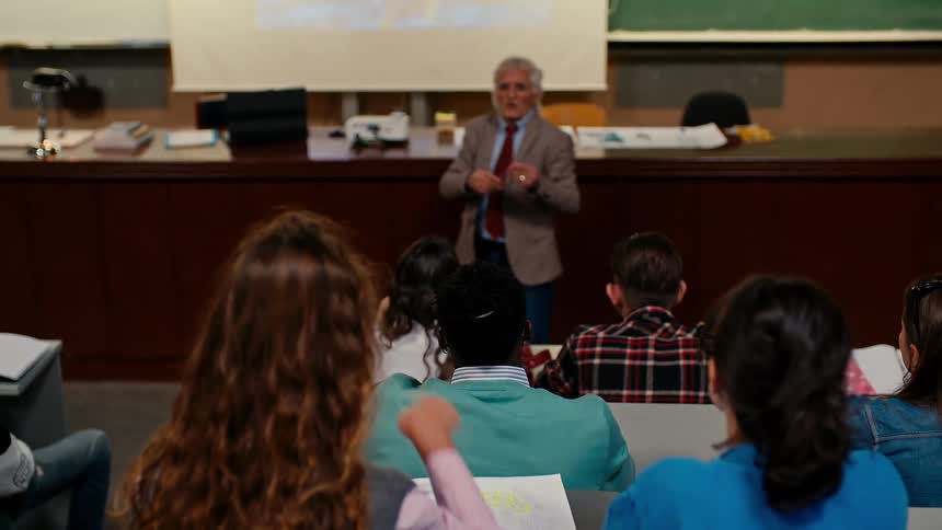 Teacher giving a lesson to students who raise their hands and interact
