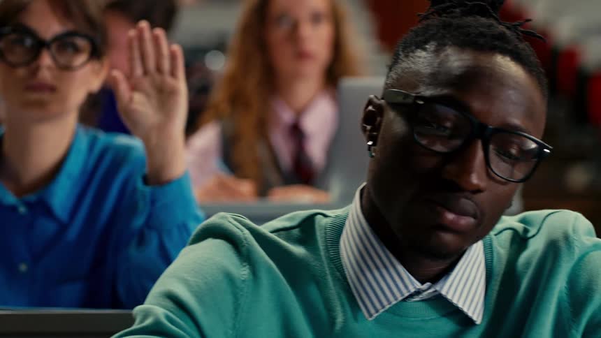 College students raising their hands in the classroom