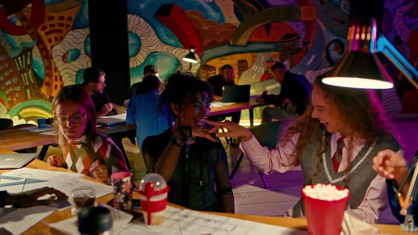 A group of students seated together on a colorful cafeteria