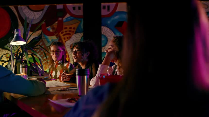 College students studying together at a table in a room with colorful walls