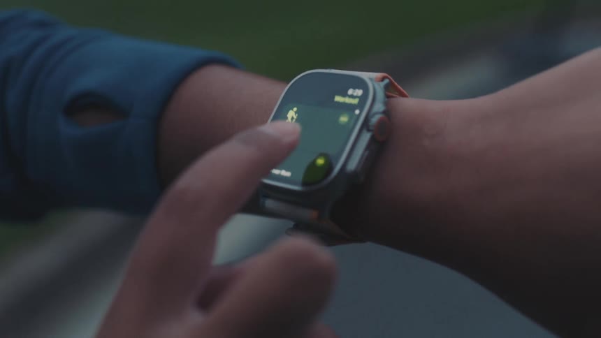 Womans hand putting her apple watch ultra into running mode