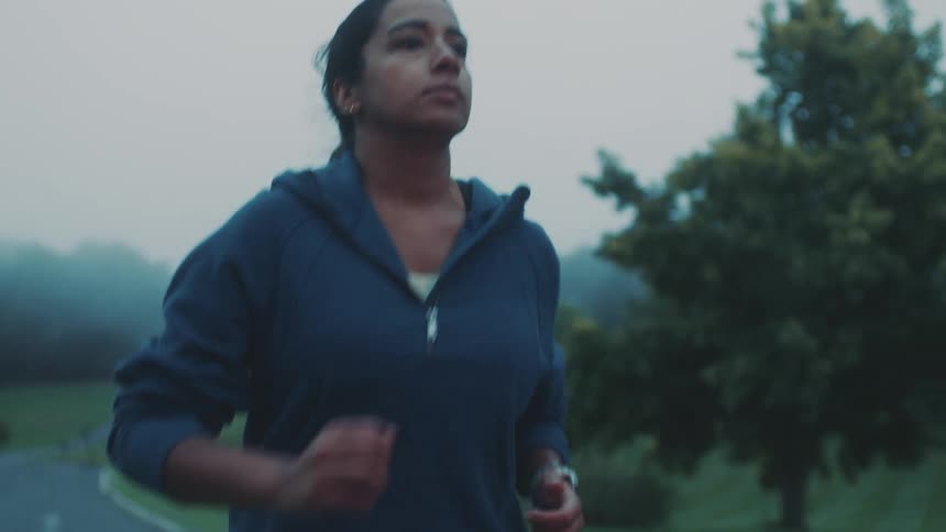 Woman in blue jacket running outdoors