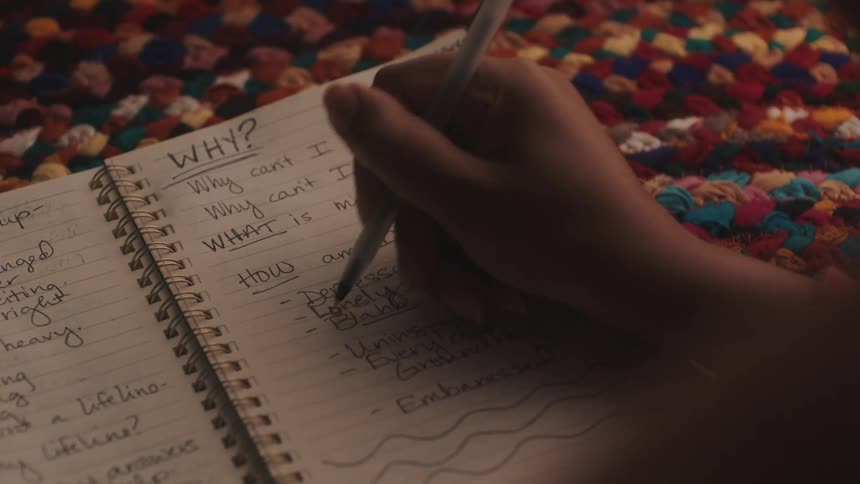A clip of a person writing on a jotter