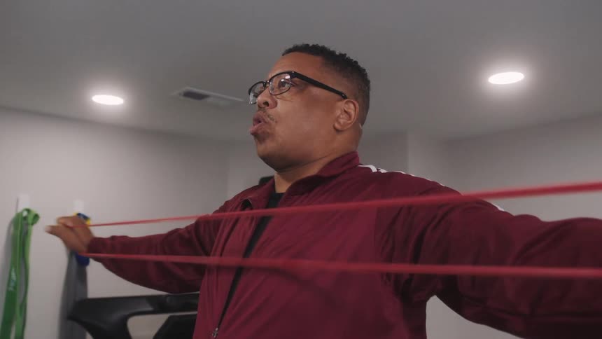 Man using a resistance band and stretching his arms