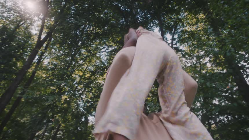 Girl running and jumping on her fathers lap in a garden